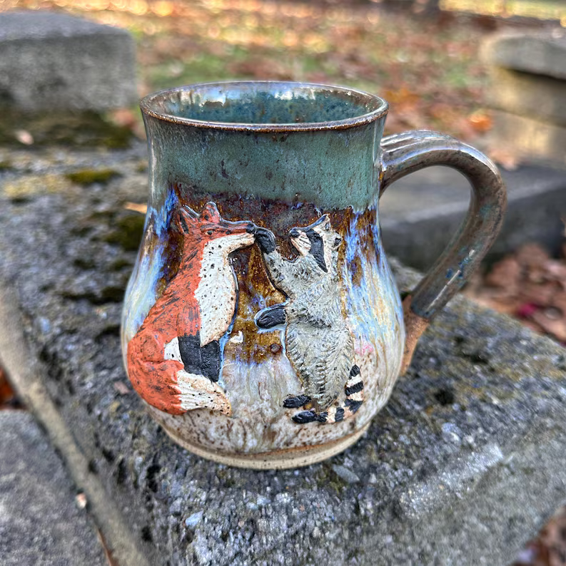 Handmade Ceramic Pottery Mug featuring a Raccoon and Fox touching noses - BOOP! Made by Sage and Slip of the Lehigh Valley